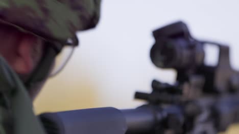 Soldier-firing-assault-rifle,-bullets-flying-out-of-ejection-port,-closeup,-handheld