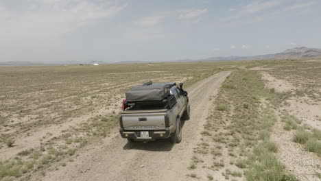 Explorer-jeep-driving-on-dirt-road-in-arid-steppe,-Vashlovani,-Georgia