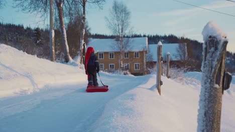 A-little-boy-pulls-a-sleigh-on-a-Christmas-day-in-winter-in-Norway