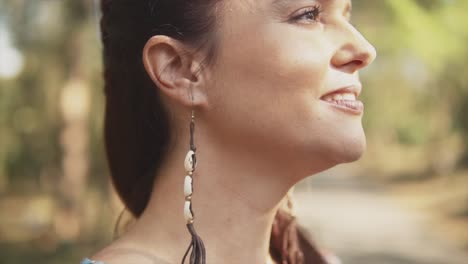 Up-close-side-view-of-a-woman-with-black-and-white-earrings-blinking-and-smiling