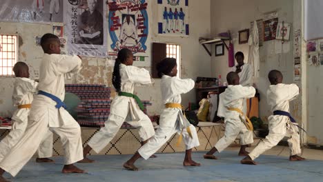 A-group-of-kids,-girls-and-boys,-train-karate-in-a-karate-school-in-Nouakchott,-Mauritania