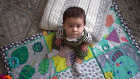 wide-shot-of-hispanic-baby-in-living-room-with-pillow-and-play-mat