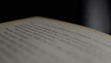 Close-up-through-an-open-book-page-with-out-of-focus-words