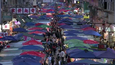 Bird's-eye-view-of-an-overcrowded-Fa-Yuen-street-stall-market-during-nighttime-as-people-look-for-bargain-priced-vegetables,-fruits,-gifts,-and-fashion-goods-in-Hong-Kong