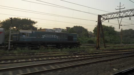 Side-view-from-a-moving-train-leaving-the-station,-India