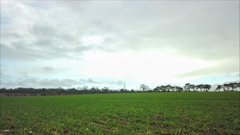 A-time-lapse-of-this-lovely-field-and-heavy-clouds-panning-to-the-right-in-Thetford,-Norfolk,-England