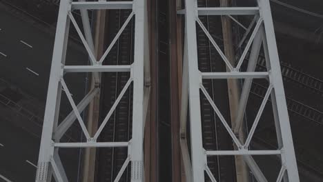 Close-up-Top-down-tracking-drone-video-of-train-tracks-on-a-bridge