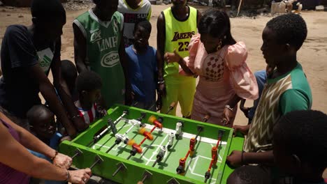 Eine-Weiße-Frau-Spielt-Tischfußball-Gegen-Eine-Schwarze-Frau-In-Einem-Viertel-Von-Nouakchott,-Mauretanien