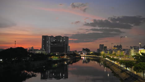 Städtisches-Flussufer-Unter-Sonnenunterganghimmel