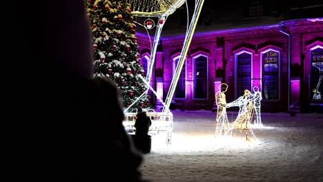 Schuss-Eines-Mit-Roten-Spielzeugen-Geschmückten-Weihnachtsbaums,-Der-Nachts-In-Raudondvaris,-Litauen,-Mit-Schnee-Bedeckt-Ist