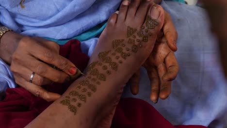 A-shot-of-female-hands-painting-a-black-foot-with-henna