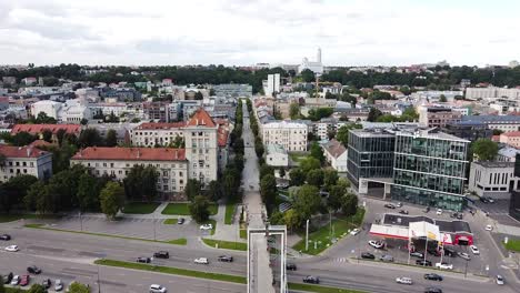 Straight-Simonas-Daukantas-street-and-pedestrian-bridge-in-Kaunas-city,-aerial-drone-view