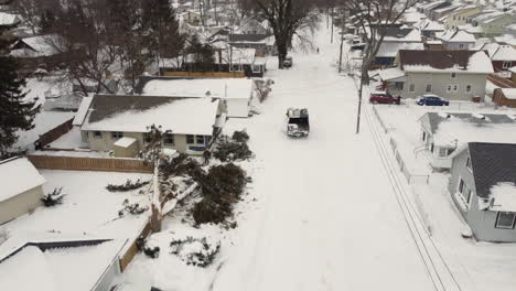 Aerial-view-of-Safety-team-Clearing-fallen-tree-near-the-house-in-a-Residential-neighborhood-covered-in-Snow