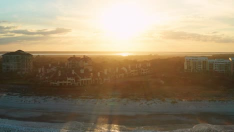 Aerial,-luxurious-ocean-beach-side-resort-homes-on-an-island-during-sunset