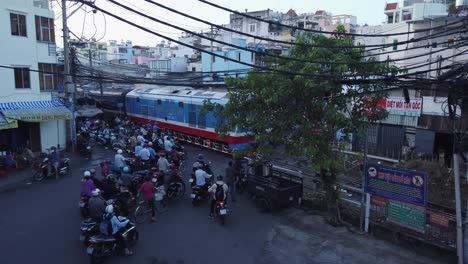 High-angle-of-Saigon-to-Hanoi-train-traveling-through-a-busy-Saigon-street-in-early-morning