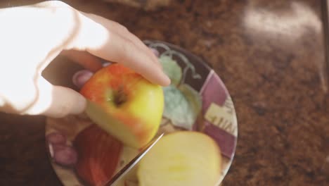 Weibliche-Hände-Mit-Einem-Küchenmesser,-Das-Apfel-Auf-Der-Arbeitsplatte-Zu-Hause-Schneidet
