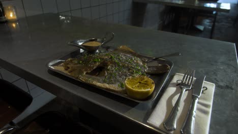 Plate-with-cod-is-served-on-a-metal-table