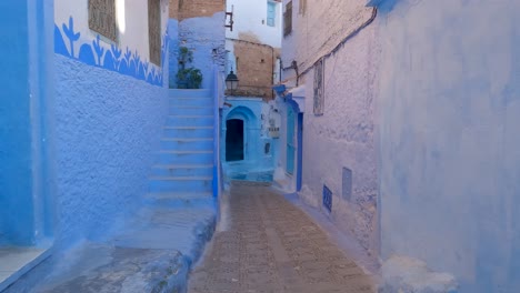 Tiro-Pov-Caminando-Por-El-Callejón-En-Chefchaouen,-Hermosas-Paredes-Pintadas-De-Azul-Vibrante,-Marruecos