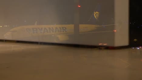 La-Reflexión-De-La-Gente-Camina-Dentro-Del-Aeropuerto-Mientras-Se-Prepara-El-Avión-Ryanair,-Lapso-De-Tiempo