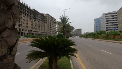 Dolly-A-La-Derecha-Revela-El-árbol-Pasado-Del-Tráfico-Que-Pasa-A-Lo-Largo-De-La-Carretera-Junto-A-Los-Desarrollos-En-El-Desarrollo-De-Viviendas-Bahria-En-Karachi