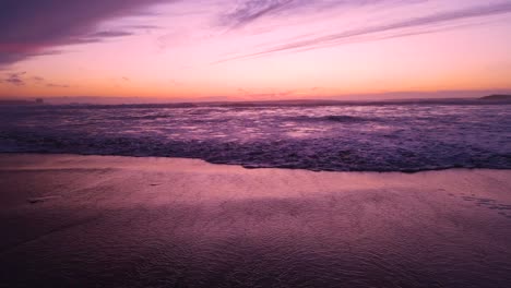 pink-ocean-waves-roll-in-at-sunset