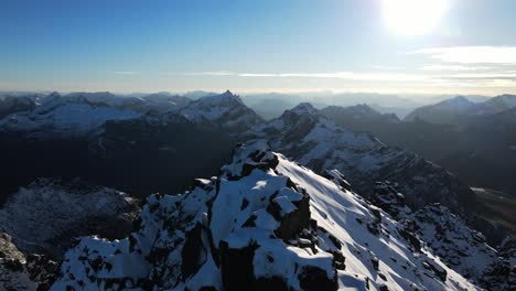 Aufsteigende-Drohnenaufnahme,-Die-Eine-Wunderschöne-Schneebedeckte-Berglandschaft-In-Norwegen-Zeigt,-Die-Von-Der-Sonne-Beleuchtet-Wird