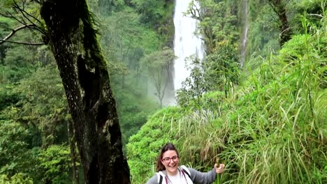 Young-female-raising-arms-happily-as-she-reached-Materuni-Waterfall