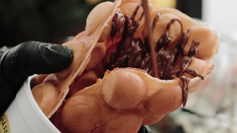 Pouring-melted-chocolate-on-a-waffle-in-a-pastry-shop