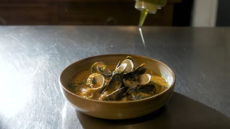 Oil-gets-added-on-a-plate-with-mussels