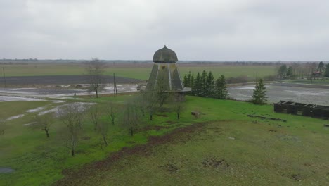 Beautiful-aerial-establishing-view-of-old-wooden-windmill-in-the-middle-of-the-field,-Prenclavu-windmill-,-overcast-winter-day,-wide-ascending-drone-point-of-interest-shot
