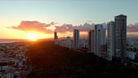 Time-lapse-of-clouds-moving-in-sky-with-blinding-setting-sun-in-background,-Santo-Domingo-city-at-sunset