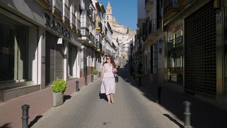 Female-Tourist-Walking-On-The-Empty-Street-Of-Olvera-Town-In-Cádiz,-Andalusia,-Spain