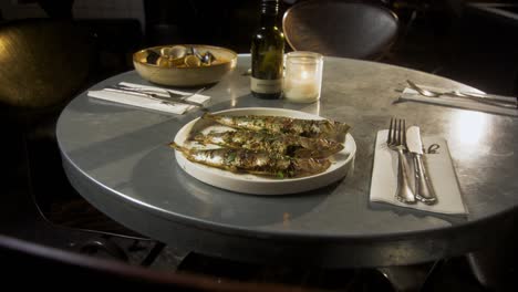 Plate-with-fish-is-served-on-a-metal-table