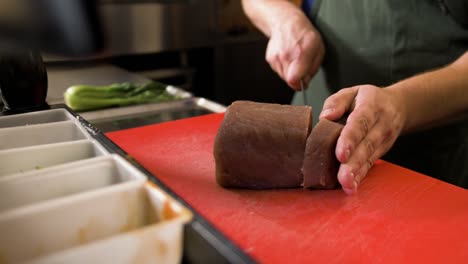 Chef-cuts-slice-of-tuna-with-knife