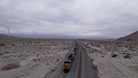 Cargo-train-passing-by-the-desert-in-Palm-Springs-with-wind-turbines