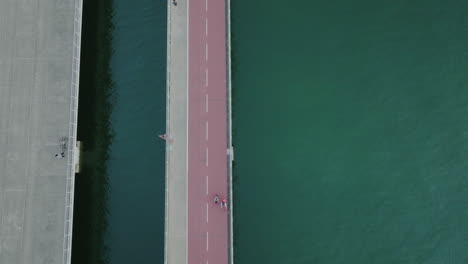 aerial-top-down-road-bridge-crossing-the-ocean-water-connecting-city-urban-infrastructure