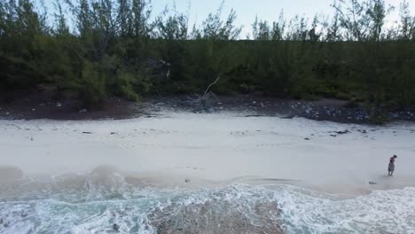 Vista-Aérea-De-Una-Mujer-Caminando-Por-La-Playa-En-Las-Bahamas