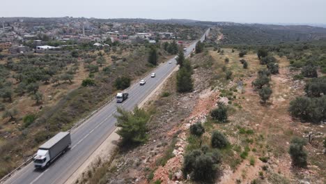 Israel-Army-squad-soldiers-on-vehicles-driving-through-country-road,-Aerial-Tracking-shot