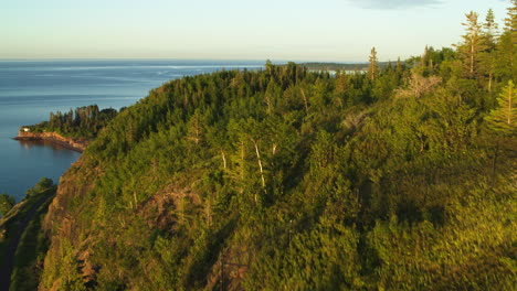 Aerial-flying-over-forest-cliff-revealing-Lake-Superior-in-North-America