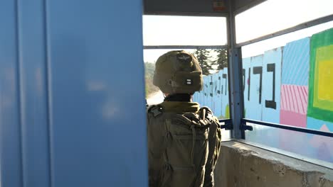 IDF-soldier-with-rifle-in-cabin-observing-road,-security-checkpoint