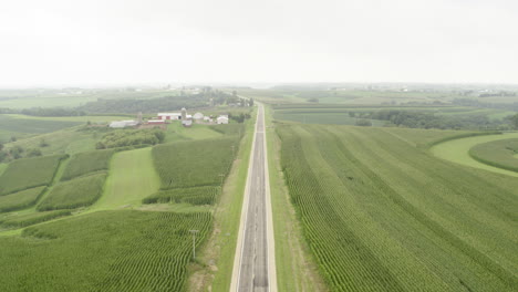 Aerial,-single-road-in-rural-agricultural-farm-field-countryside-on-overcast-day