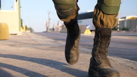 low-angle-shot-of-soldier's-in-combat-boots-approaching