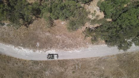 Israel-Army-squad-soldiers-on-Humvee-vehicles-driving-through-training-ground-country-road,-Aerial-top-down-shot