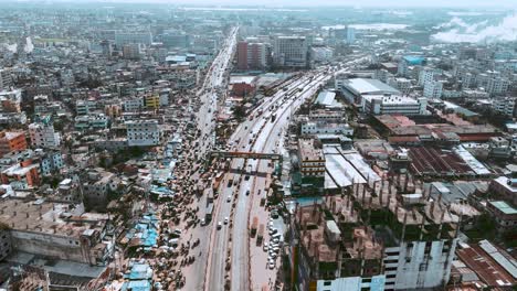Aerial-shot-of-a-busy-road-where-vehicles-are-passing-in-Dhaka,-Bangladesh