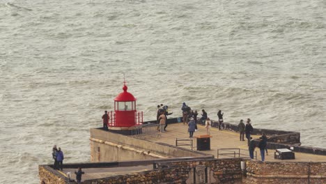 View-of-tourists-visiting-the-ocean-view-from-Farol-da-Nazaré