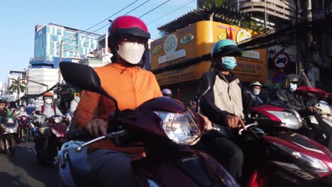 Morning-rush-hour-motorbike-traffic-on-busy-road-in-Ho-Chi-Minh-City,-Vietnam