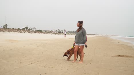 Mädchen-Genießt-Ihren-Tag-Mit-Schönem-Hund-Am-Sandstrand-Bei-Windigem-Wetter