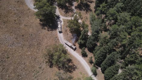 Israel-Army-vehicles-standing-in-queue-on-a-narrow-country-road,-Aerial-shot