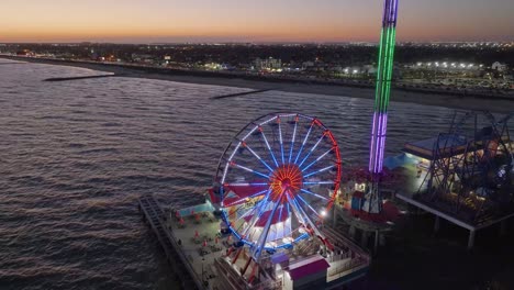 Aerial-orbit-view-around-the-illuminated-Ferris-wheel-on-the-Galveston-Island-Pier