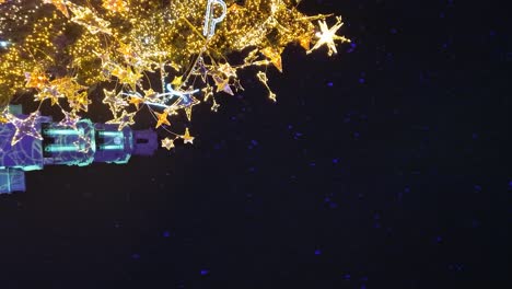 Kaunas-city-hall-and-glowing-Christmas-tree-during-snowfall,-vertical-video